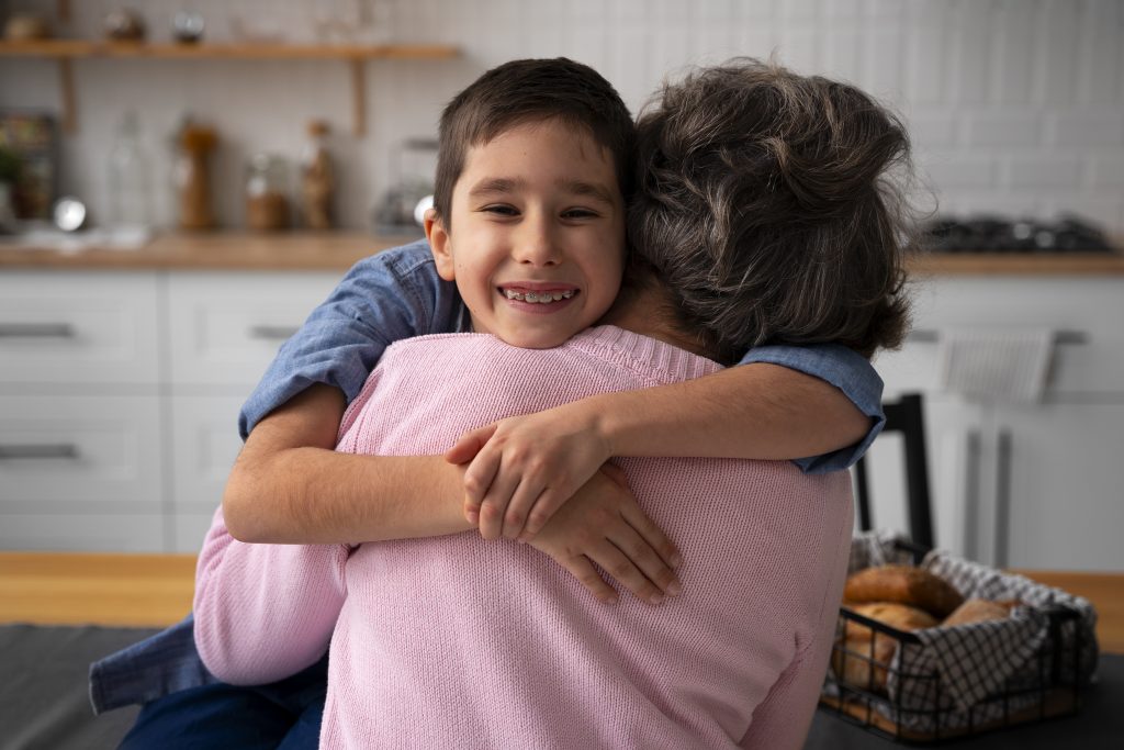 Criança sorridente abraçando a mãe em casa, representando apoio, afeto e equilíbrio na maternidade atípica.