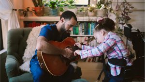 terapeuta utiliza musicoterapia com criança com paralisia cerebral.